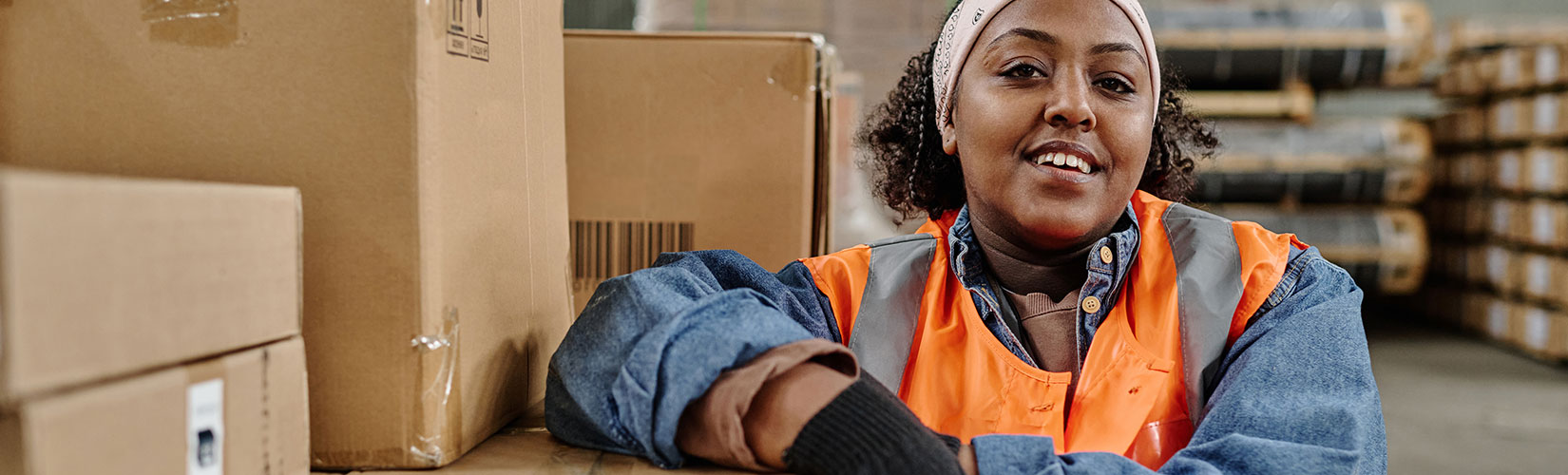 woman smiling in warehouse next to boxes