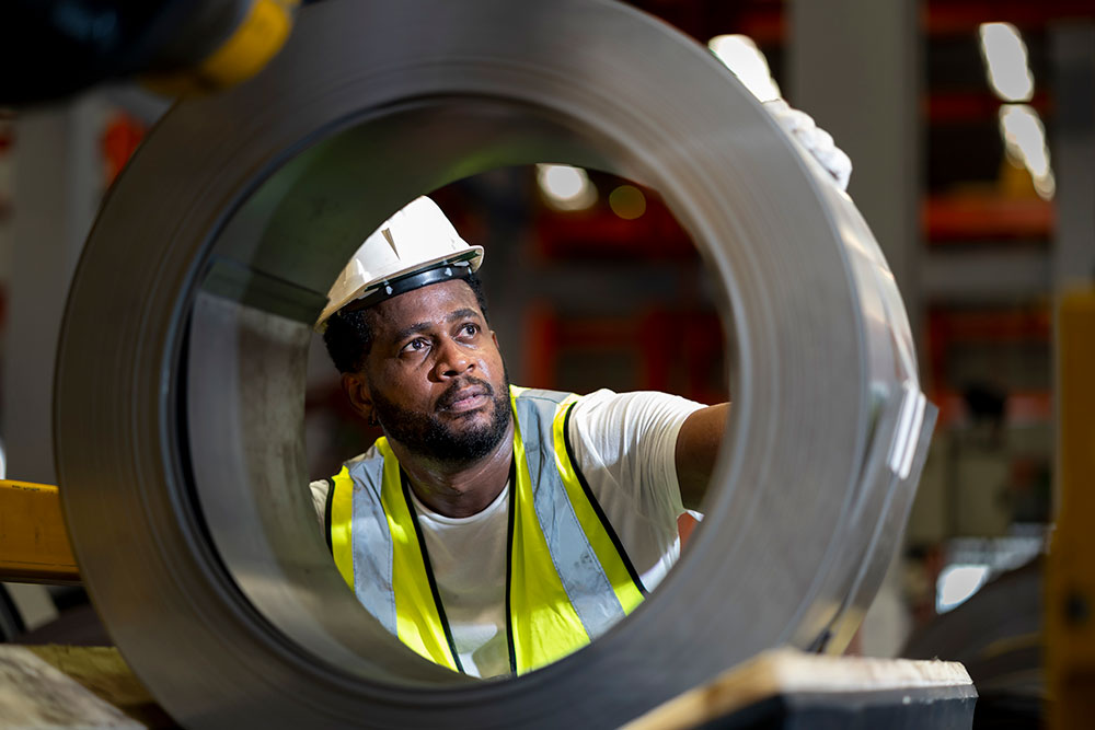 man working on metal pipe segment photo