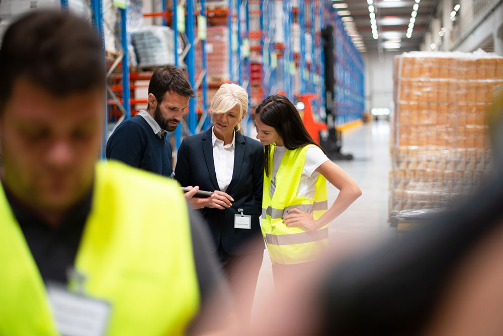 woman in suit with employees in warehouse photo