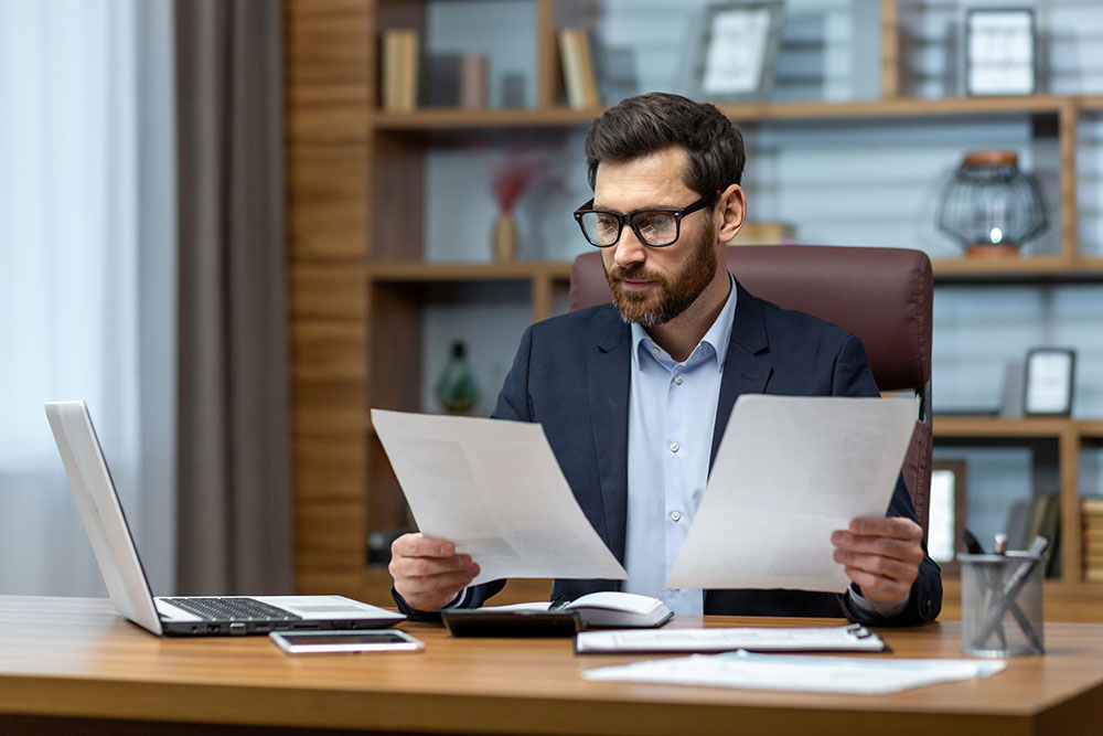 man reviewing documents at desk photo